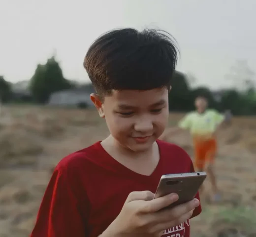 Young boy at beach on his phone